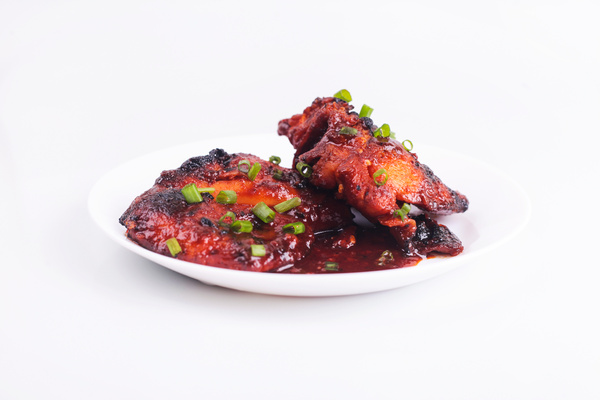 Grilled chicken or ayam golek on plate, white background.