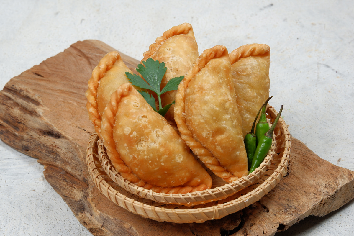 Curry puff or Pastel Goreng is Pastry Popular in Indonesia. fried pastry with filling of sautéed vegetable , chicken and boiled egg. accompanied with sauce or raw chilli pepper